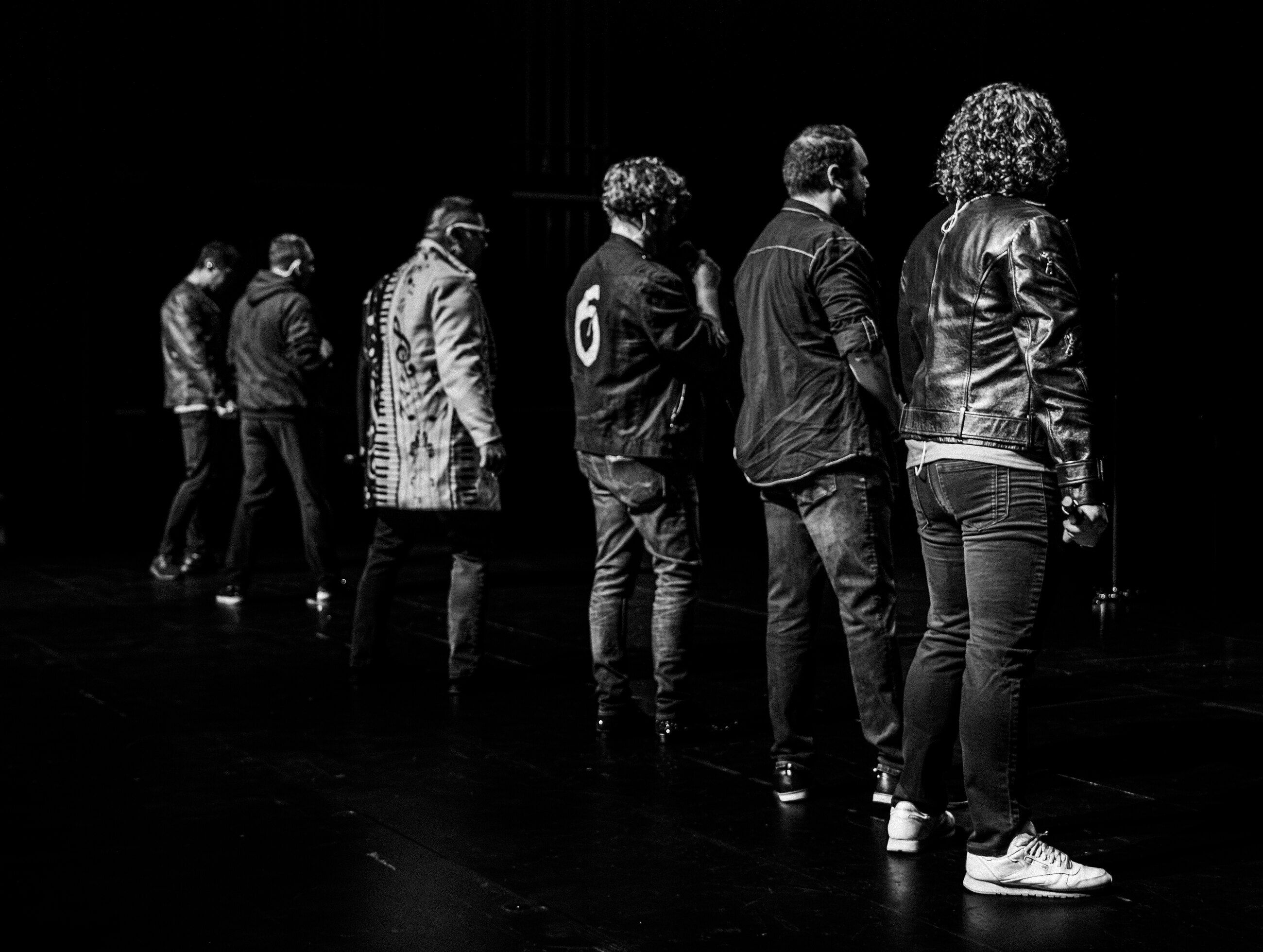 6 Minute Warning walking off stage in a line, shot from behind in black and white