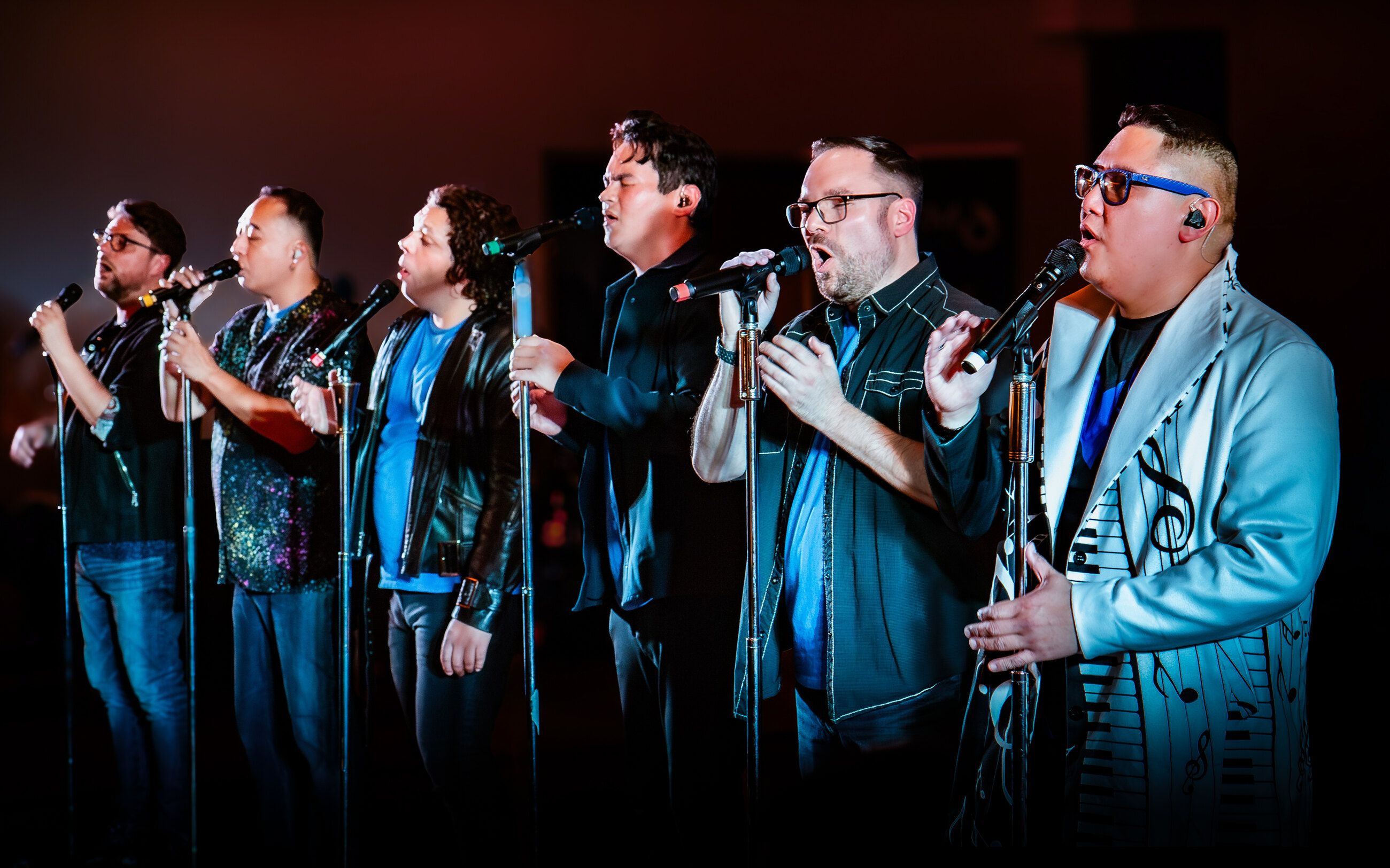 The 6 members of 6 Minute Warning singing in a row on stage